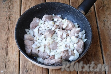 Очищенный лук нарезать кубиками, выложить к мясу, продолжить приготовление на среднем огне, периодически помешивая, до прозрачности лука.&nbsp;
