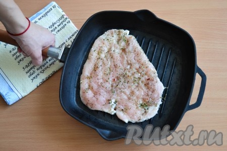 С обеих сторон отбивные посолить и приправить прованскими травами. Разогреть сковороду гриль или можно воспользоваться обычной сковородой с покрытием, которое позволяет жарить без масла (антипригарным покрытием). Выложить на сухую сковороду одно отбитое филе. Обжарить 2-2,5 минуты на среднем огне с одной стороны (масло мы не добавляем), затем перевернуть и обжарить отбивную с другой стороны в течение 2 минут. Если у вас нет сковороды гриль или сковороды с антипригарным покрытием, то можете влить немного водички на обычную сковороду и жарить с небольшим добавлением воды. Но необходимо постоянно приглядывать, чтобы вода не выпарилась окончательно и, возможно, ее подливать. Воды много добавлять не нужно, она должна образовывать тонкий слой между мясом и сковородой и окончательно выпариться, когда мы начнем переворачивать отбивную на другую сторону. Потом опять подливаем водичку и жарим отбивную с другой стороны. Аналогично пожарить вторую куриную отбивную.
