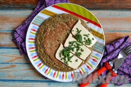 Сочный, нежный, ароматный овсяноблин готов. Подать его можно с сыром и зеленью. Для этого овсяноблин нужно выложить на блюдо, а сверху на одну сторону разместить ломтики сыра, посыпать измельченной зеленью. Я использую сыр тоффу, а вы выбирайте сыр на свое усмотрение - твердый или мягкий. На что следует обратить внимание, так это на содержание соли, если сыр солоноватый, то не добавляйте тогда соль в само тесто.
