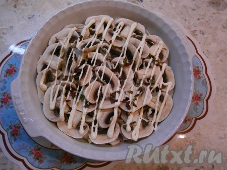 Шампиньоны нарезать пластинами и выложить их следующим слоем, посолить и немного смазать майонезом.
