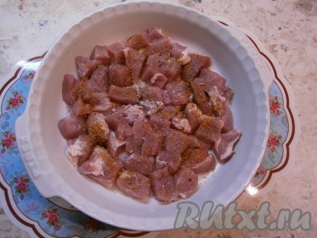 Мясо нарезать небольшими кусочками, выложить его в большую форму для запекания (у меня диаметр формы 26 см), смазанную растительным маслом. Мясо посолить, поперчить, посыпать специями.
