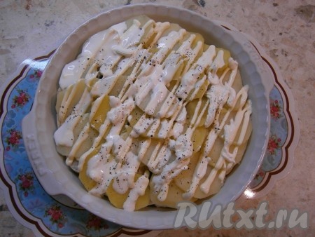 Картофель откинуть на дуршлаг, дать ему остыть до теплого состояния и выложить сверху грибов. Немного еще посолить картошку, смазать щедро сметаной и майонезом, поперчить.
