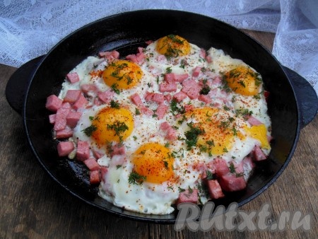 Жарьте яичницу с колбасой без крышки на среднем огне до готовности (около 2-3 минут) - белок должен полностью схватиться, а желток внутри останется достаточно жидким. Если вы любите не жидкий белок, то можете жарить яичницу, накрыв сковороду крышкой. Готовое блюдо можно, по желанию, посыпать мелко нарезанным укропом.
