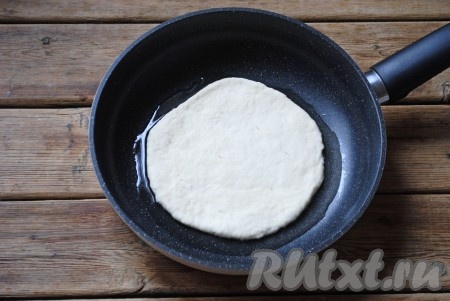 По истечении времени обмять тесто и разделить его на пять равных частей. Каждую часть теста раскатать в лепёшку толщиной около 0,5 см. По всей поверхности каждой лепёшки ножом или вилкой сделать проколы. Сковороду с растительным маслом хорошо разогреть, выложить лепёшку.
