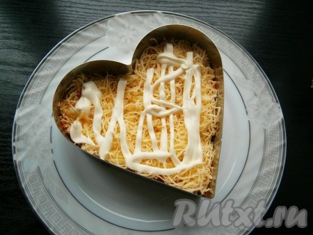 Смазать морковь с чесноком майонезом. Далее выложить слой натертого на той же терке твердого сыра + майонез.