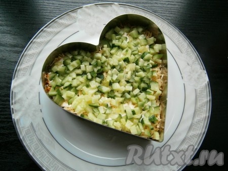 Следующим слоем выложить нарезанный маленькими кубиками свежий огурец + майонез.
