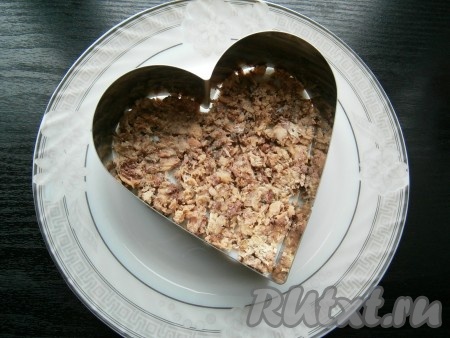 На плоскую тарелку с помощью кулинарного кольца выложить рыбу первым слоем.
