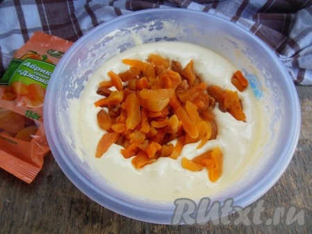 Затем введите курагу и ложкой перемешайте тесто.
