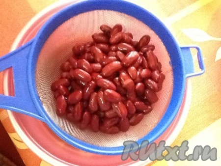 Фасоль из банки выложить в сито, промыть кипячёной водой. Оставить, чтобы вода стекала.