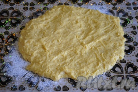 Когда тесто подойдёт второй раз, выложить его на стол, присыпанный мукой. Растянуть тесто в пласт. Тесто по-прежнему будем очень мягким и липким, поэтому руки лучше смазать растительным маслом.