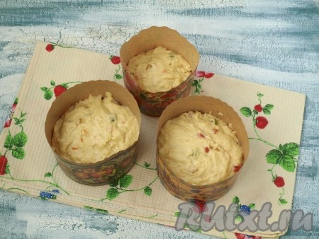 Разложить тесто в бумажные формы, заполняя их на 1/3 или на половину объёма. Накрыть формы сверху полотенцем и дать тесту подняться до края форм.