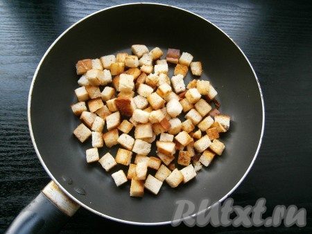 Выключить газ, отставить чесночный суп, накрыв крышкой. Батон нарезать небольшими кубиками, выложить в сковороду с 1 столовой ложкой разогретого растительного масла, обжарить на небольшом огне до румяного цвета со всех сторон.
