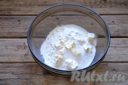 Добавить охлаждённое сливочное масло, натёртое на тёрке или нарезанное небольшими кубиками. Руками перетереть получившуюся массу в крошку.

