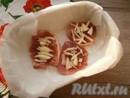 Поместить мясо в небольшую форму, застеленную пергаментом и смазанную растительным маслом. На мясо выложить нарезанный тонкими четвертинами очищенный репчатый лук.
