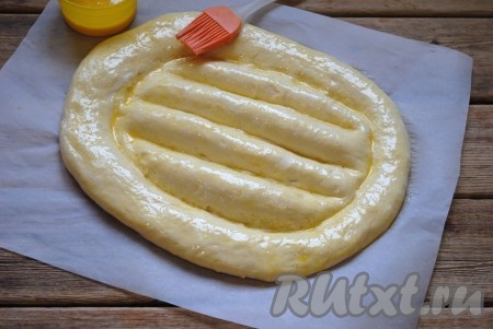 
Накрыть заготовку полотенцем и оставить на 10-15 минут. Затем смазать поверхность хлеба взбитым яйцом.
