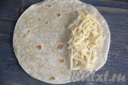 Сформировать кесадилью, для этого на край лепёшки выложить немного сыра.
