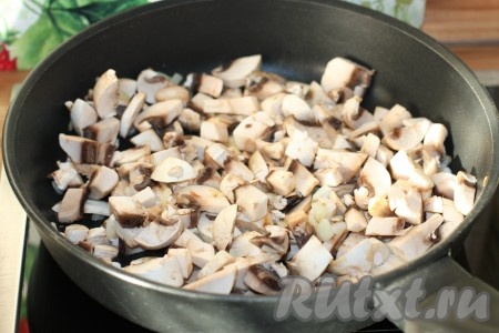Шампиньоны нарезать средними кубиками, добавить к луку и обжарить на небольшом огне, помешивая, до готовности (в течение 5-7 минут), посолить, поперчить.
