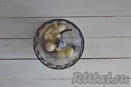 Очистить и вымыть лук с чесноком, а затем перемолоть мясорубкой или измельчить блендером.
