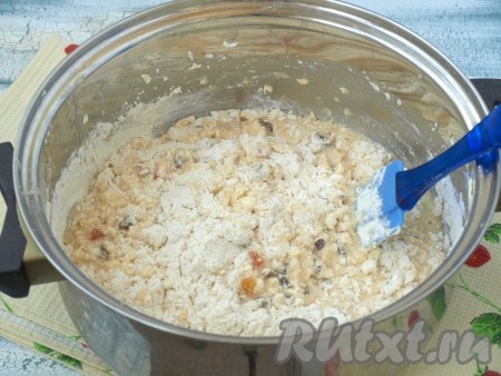 К взбитым яйцам добавить поднявшуюся опару, высыпать сухофрукты вместе с коньяком, взбить венчиком. Добавить мягкое сливочное масло и половину просеянной муки. Размешать тесто лопаткой.
