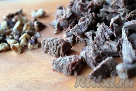 Мясо нарезать на кусочки, грецкие орехи порубить.