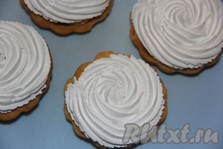 Отсадить взбитые сливки на пирожные, закрывая начинку корзинок (как на фото).
