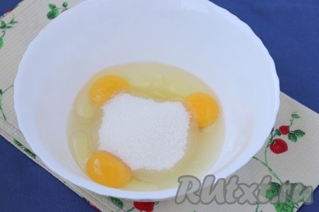 Вишню, если замороженная, достать из морозилки и оставить до полной разморозки в дуршлаге, чтобы ушёл лишний сок. Также достать сливочное масло, чтобы оно стало мягким. Разбить в миску яйца, добавить сахар.
