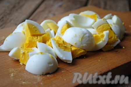 4 яйца залить водой и отварить вкрутую на среднем огне (в течение 9-10 минут с момента закипания). Затем остудить, очистить и нарезать крупными кусочками произвольного размера.