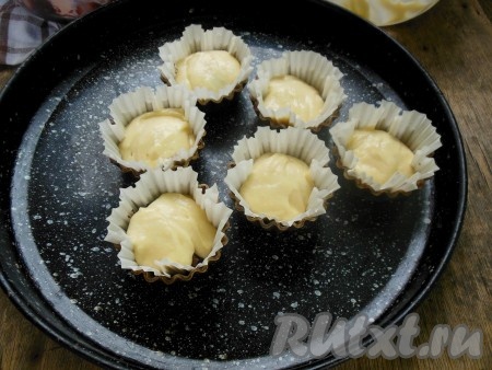 В формочки для кексов поставьте бумажные капсулы, смазывать их не нужно. Если у вас нет бумажных капсул, то смажьте железные формочки растительным или сливочным маслом, силиконовые формочки можно не смазывать. С помощью чайной ложки заполните форточки тестом на 2/3 объёма, выкладывая поочередно два вида теста (например, вначале выложите ложечку шоколадного, сверху - белое, затем - снова шоколадное и продолжайте чередовать, пока формочки не заполнятся на 2/3 объёма). На каждый кекс у меня ушло, примерно, по 4-5 чайных ложек теста.