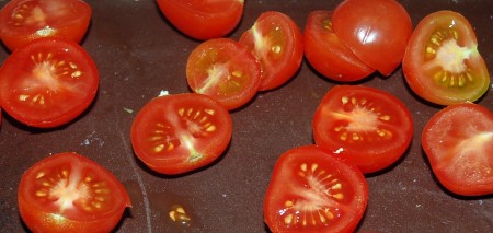 Нарезать помидоры черри на половинки.