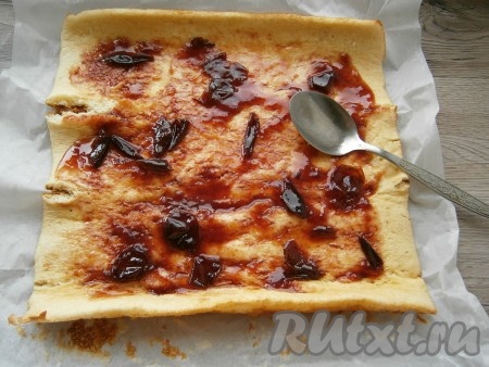 Развернуть корж, отделить его от пергамента. Смазать корж любым вареньем или джемом, вареной сгущенкой и т.д. У меня - сливовый джем.
