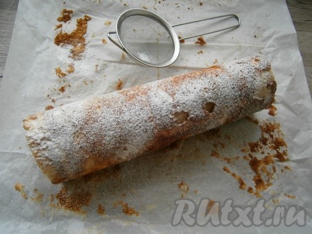 Затем корж снова поплотнее свернуть в рулет. Посыпать рулет сахарной пудрой.
