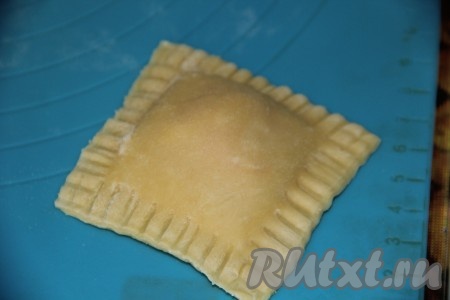 Края теста скрепить с помощью вилки. Аналогично раскатать оставшееся тесто и сформировать равиоли.
