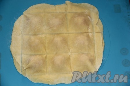 Тонко раскатать второй пласт теста и накрыть фарш. С помощью деревянной лучины или тупым краем длинного ножа придать квадратную форму будущим равиоли (как на фото).
