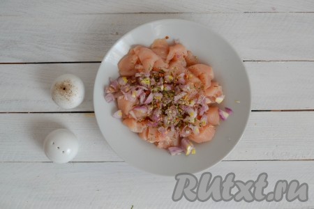 К мясу и луку всыпать соль, черный молотый перец и прованские травы.
