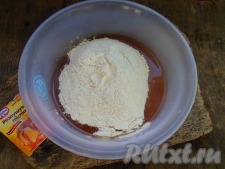 Затем добавьте 200 грамм муки и весь разрыхлитель. Перемешивайте тесто сначала столовой ложкой, постепенно подсыпая оставшуюся муку. Когда тесто станет густым, перейдите на замес руками.