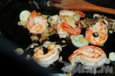 Обжарить на оливковом масле лук порей и креветки в течение 2-3 минут.
