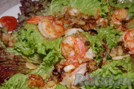 Выложить обжаренные креветки с луком пореем на листья салата.
