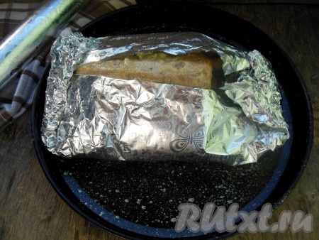 Противень застелите фольгой для запекания в три слоя. Веточки чабреца и колечки лимона уберите во внутрь утки к чесноку. В центр фольги спинкой вниз выложите утку. Заверните птицу в фольгу со всех сторон, сверху накройте еще двойным слоем фольги, но только так, чтобы можно было легко раскрыть верх фольги.