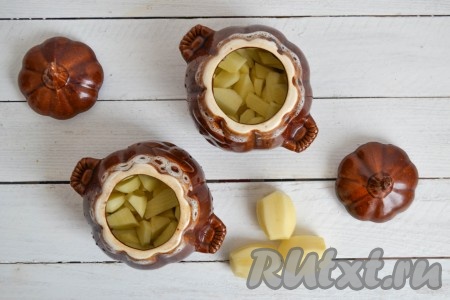 Очистить картофель, нарезать небольшими кусочками и, равномерно распределяя, разложить по горшочкам, приправить солью и прованскими травами.
