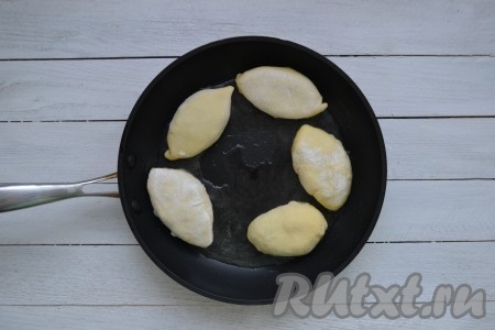 Слегка прижать каждый пирожок сверху ладошкой, придавая приплюснутую форму. Когда все заготовки будут готовы, можно приступать к жарке. Вначале нужно жарить пирожки, которые слепили первыми, так как они уже "отдохнули" и немного подошли. В сковороду влить 50-70 мл растительного масла и, когда оно хорошо разогреется, выложить заготовки пирожков. Обжарить с каждой стороны до румяности (минут по 6-7) на умеренном огне.&nbsp;
