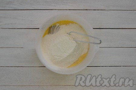 Перемешать и сразу же всыпать половину порции просеянной муки.
