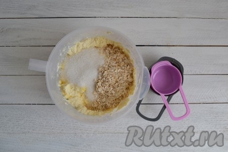 В смесь творога и яиц всыпать сахар и муку. Я вместо муки решила добавить овсяные хлопья. Хлопья можно использовать любые: крупные или мелкие.
