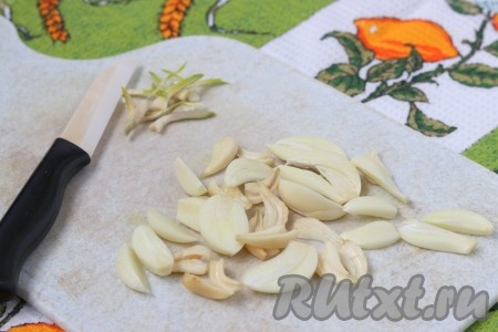 Первым делом подготовить чеснок. Зубчики чеснока очистить от шелухи, удалить проросшие зеленью сердцевины и нарезать пластинками.
