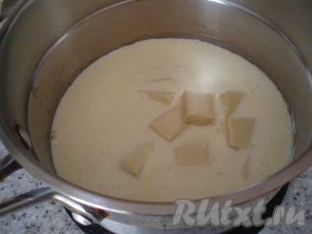 Добавить к сливкам кусочки белого шоколада и размешать, чтобы шоколад расплавился.