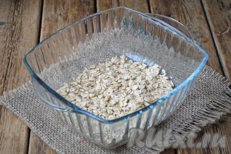 Овсяные хлопья залить холодной водой, перемешать, накрыть крышкой и отправить в микроволновку.