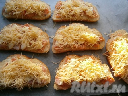 Сверху бутерброды с рыбой посыпать натертым на средней терке твердым сыром.
