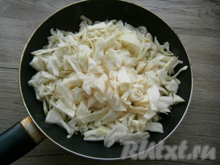 В ту же сковороду влить оставшееся растительное масло, выложить нашинкованную или нарезанную некрупно капусту, немного посоленную и помятую руками.
