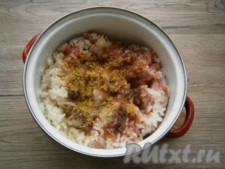 Остывший рис добавить к фаршу, всыпать соль, перец и приправу по вкусу, тщательно перемешать.
