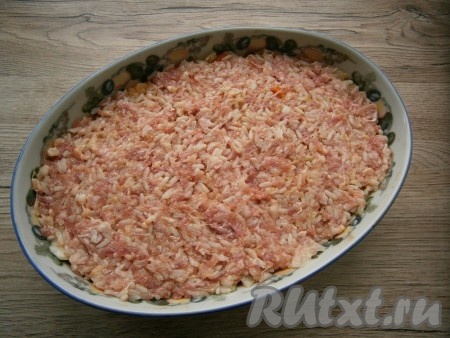 Далее приготовить форму или кастрюлю для запекания. Выложить в нее половину обжаренной капусты с овощами, сверху разместить весь фарш с рисом, разровнять.
