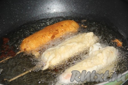 Растительное масло хорошо разогреть. Для жарки корн-догов я использовала глубокую сковороду. Выложить сосиски в тесте в разогретое масло (во фритюр).
